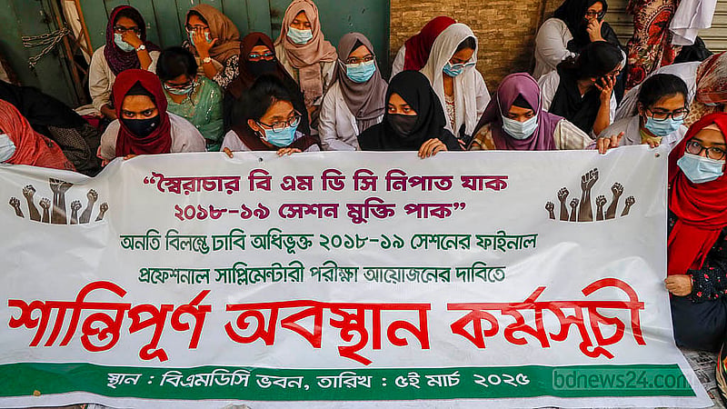 পরীক্ষা এগিয়ে আনার দাবিতে বাংলাদেশ মেডিকেল অ্যান্ড ডেন্টাল কাউন্সিলের (বিএমডিসি) সামনে ব্যানার নিয়ে অবরোধে শিক্ষার্থীরা