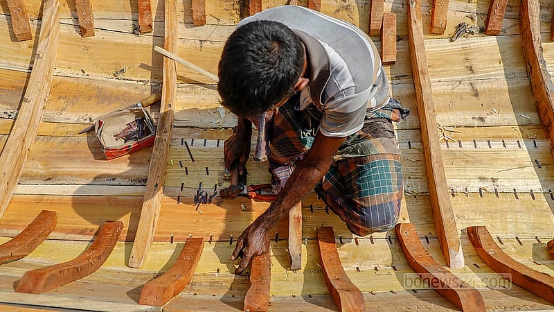 বুড়িগঙ্গা নদীর তীরে ২৫ বছর ধরে নৌকা বানানো কাজ করছেন আমির হোসেন। কাঁঠাল কাঠের নৌকাটি বানাতে তার সময় লাগবে ৭ দিন; কাজ এখন শেষ পর্যায়ে। নৌকা বানানো হয়ে গেলে এটি বিক্রি হবে ২৫ হাজার টাকায়