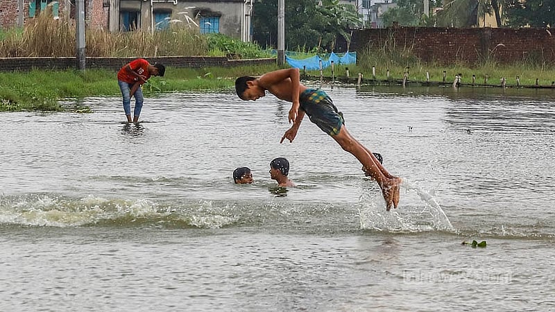 বৃষ্টির পানিতে তলিয়েছে সড়ক, তার পাশের পুকুরে দুরন্তপনায় মেতে ওঠেছে কয়েক কিশোর। ঢাকার মাতুয়াইল মেডিকেল রোডের শহিদনগর এলাকায় বৃহস্পতিবার দেখা গেছে এই দৃশ্য
