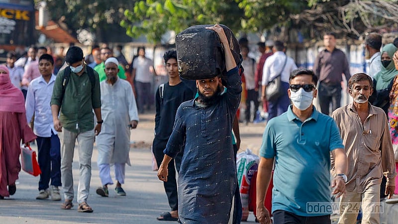 অবরোধের কারণে যান চলাচল বন্ধ; ঢাকার খিলগাঁও এলাকায় মাথায় ব্যাগ নিয়ে হেঁটে গন্তব্যের পথে এক ব্যক্তি