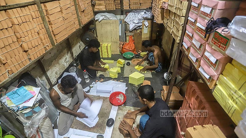 রাজধানীর বাবুবাজার হাসান আলী লেইনের একটি কারখানায় কাগজের প্যাকেট ও খাম তৈরি করছেন শ্রমিকরা