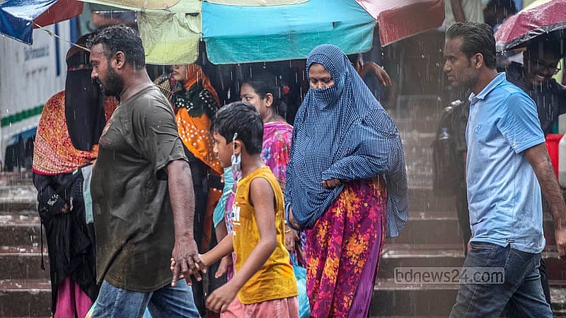 বৃষ্টিতে ভিজে গন্ত্যেবে ছুটছে মানুষ। মঙ্গলবার ঢাকার মুগদা এলাকা থেকে তোলা