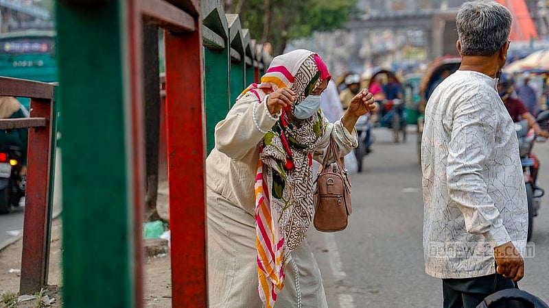 ঢাকার নিউ মার্কেট এলাকায় সড়ক বিভাজকের মধ্য দিয়ে ঝুঁকি নিয়ে সড়ক পার হন অনেক মানুষ