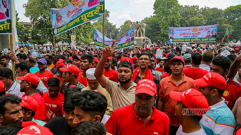 ঢাকা বিশ্ববিদ্যালয় এলাকায় রোববার দুপুরে দলের ব্যানার হাতে নেতা কর্মীরা। সোহরাওয়ার্দী উদ্যানে আওয়ামী লীগের ৭৫তম প্রতিষ্ঠাবার্ষিকীর সভায় যোগ দিতে এসেছেন তারা