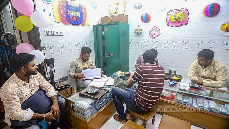 বাংলা নববর্ষের প্রথম দিন তাঁতীবাজারে একটি দোকানে নতুন টালিখাতায় তোলা হচ্ছে দেনা-পাওনার হিসাব