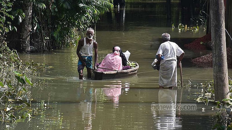 ফেনীর বিরলী বাজার রতনপুর গ্রামের নিচু এলাকায় এখনও কোমর সমান পানি। নৌকা দিয়ে নারীদের পার করছে এক বৃদ্ধ