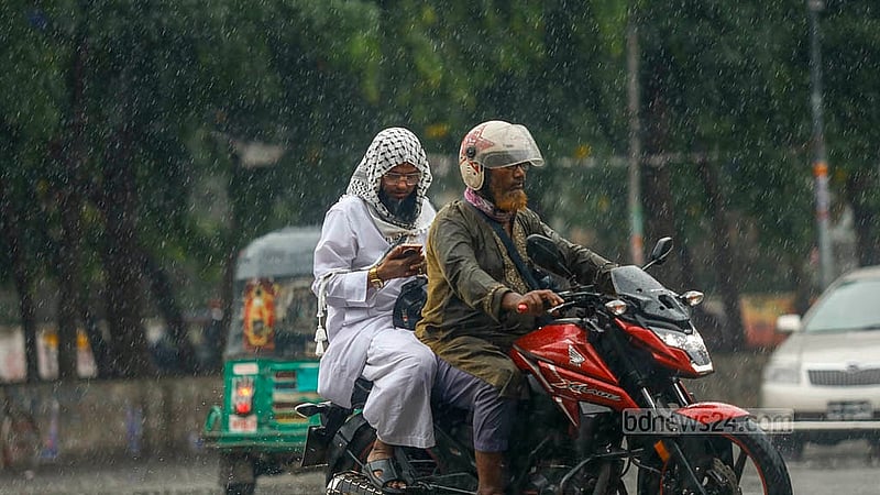 ঢাকা বিশ্ববিদ্যালয়ে এলাকায় বৃহস্পতিবার দুপুরে ঝুম বৃষ্টিতে ভিজে গন্তব্যের পথে দুই বাইক আরোহী