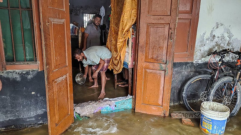 জলাবদ্ধ কুমিল্লা ভিক্টোরিয়া সরকারি কলেজের কাজী নজরুল ইসলাম হলে কক্ষ থেকে পানি সরাচ্ছেন শিক্ষার্থীরা