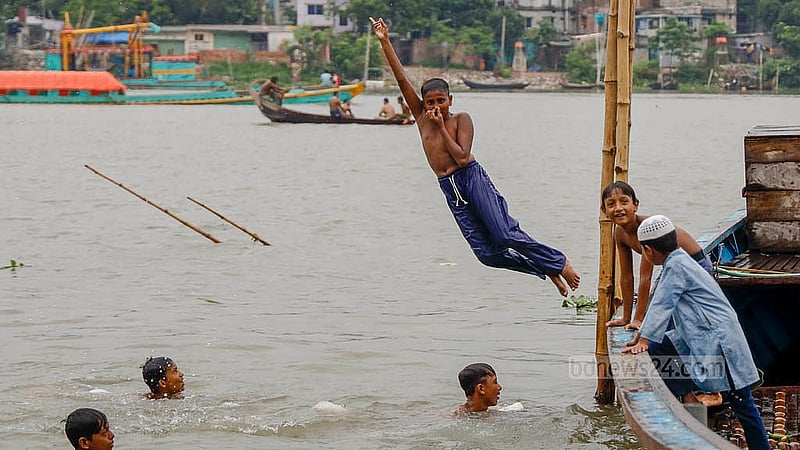 ঢাকার কামরাঙ্গীরচর অংশে ঘাটে নোঙ্গর করা ট্রলার থেকে বুড়িগঙ্গায় লাফাচ্ছে কিশোরদল