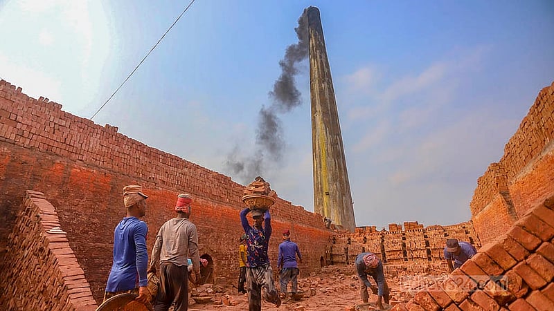 ঢাকার দক্ষিণ কেরাণীগঞ্জের জাজিরা এলাকার একটি ইটভাটার চিমনি থেকে এখনও ধোয়া বের হলেও একপাশ থেকে ইট নামাচ্ছেন শ্রমিকরা