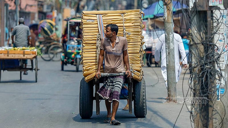 কাঠফাটা রোদে ঢাকার লালবাগ এলাকায় মালবোঝাই ঠেলা গাড়ি নিয়ে যাচ্ছেন একজন