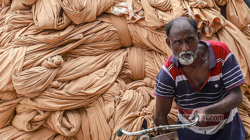 নারায়ণগঞ্জের ফতুল্লার হাজীগঞ্জ এলাকার একটি মাঠে কাপড় শুকানোর পর নিয়ে যাওয়া হচ্ছে কারখানায়