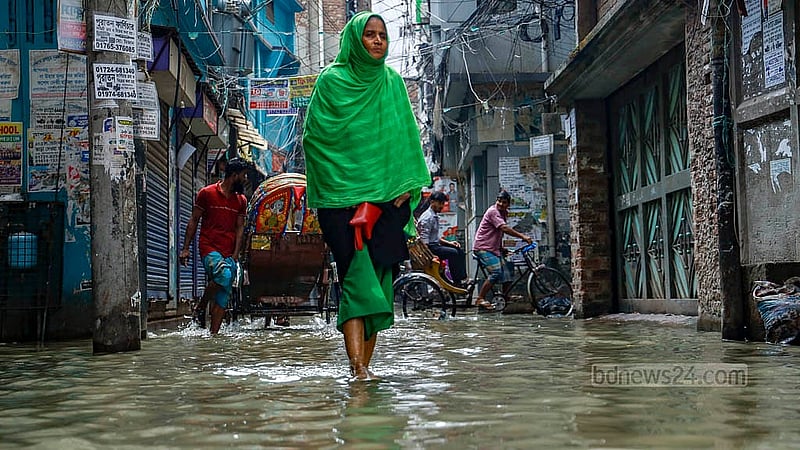 পুরান ঢাকার বংশালে আব্দুল হাদী লেনের নোংরা পানি মাড়িয়ে যাচ্ছেন এক নারী। টানা বৃষ্টি হলেই এই এলাকায় জলাবদ্ধতা তৈরি হয়