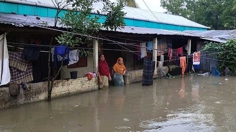 টানা বৃষ্টি ও পাহাড়ি ঢলে কুমিল্লায় বন্যা দেখ দেওয়ায় পানিবন্দি হয়ে পড়েছেন অনেক মানুষ। ডুবে যাওয়া ঘরের সামনে দাঁড়িয়ে দুই নারী।