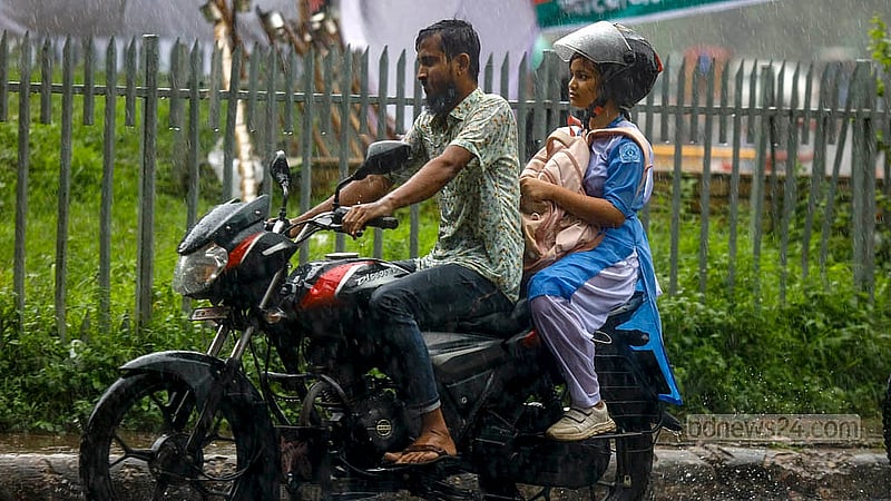 ঢাকা বিশ্ববিদ্যালয় এলাকায় রোববার দুপুরের ঝুম বৃষ্টির মধ্যেই ভিজতে ভিজতে গন্তব্যের পথে মোটরসাইকেল চালক ও তার আরোহী