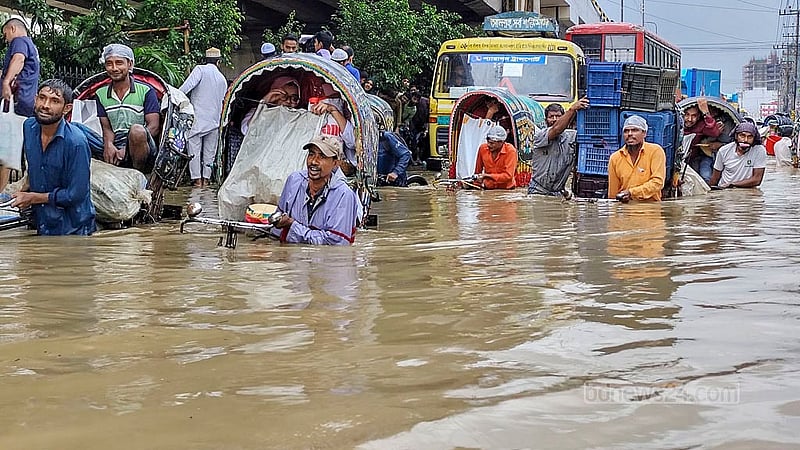 মঙ্গলবার সকালের টানা বৃষ্টিতে জলাবদ্ধতায় খালের পানি উপচে চট্টগ্রাম নগরীর মুরাদপুরে সড়কে কোমড় সমান পানির মধ্যে রিকশা নিয়ে গন্তব্যের উদ্দেশে চালকরা