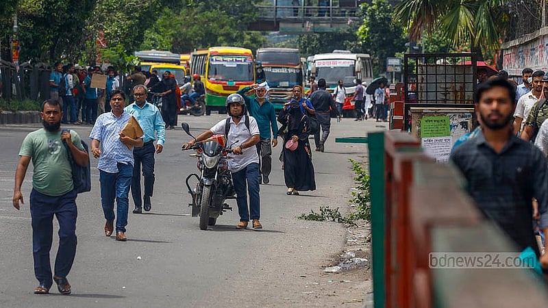সায়েন্স ল্যাবরেটরি মোড়ে বুধবার কোটা আন্দোলনকারীদের অবরোধের সময় হেঁটে গন্তব্যের পথে মানুষ