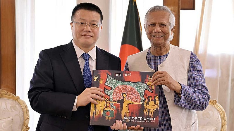 বৈঠকের পর প্রধান উপদেষ্টা মুহাম্মদ ইউনূস জুলাই অভ্যুত্থানের ওপর শিক্ষার্থীদের আঁকা দেয়ালচিত্রে নিয়ে প্রকাশিত বই চীনের রাষ্ট্রদূত ইয়াও ওয়েনকে উপহার দেন। ছবি: পিআইডি 