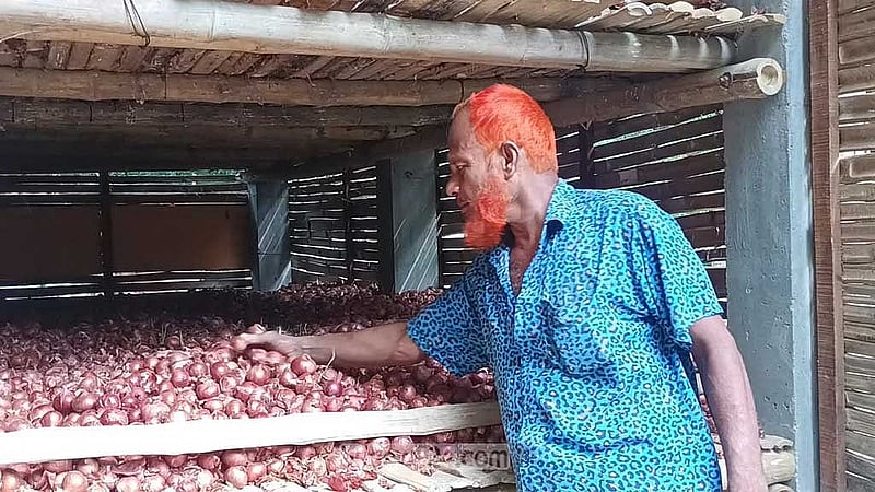 বাড়ির উঠানে পেঁয়াজ সংরক্ষণের মডেল ঘরের সামনে বালিয়াকান্দি উপজেলার করমচাঁদপুর গ্রামের চাষি মোহাম্মদ লুৎফুর রহমান।