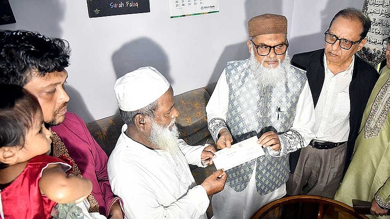 আইনজীবী সাইফুল ইসলাম আলিফের পরিবারের হাতে সহায়তার চেক তুলে দিচ্ছেন ধর্ম উপদেষ্টা।  
