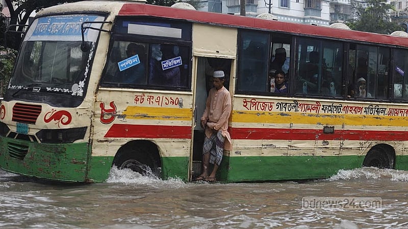হোটেল ইন্টারকনটিনেন্টাল সংলগ্ন সড়কে বাসের দরজা ছুঁইছুঁই বৃষ্টির পানি। ছবি: মাহমুদ জামান অভি