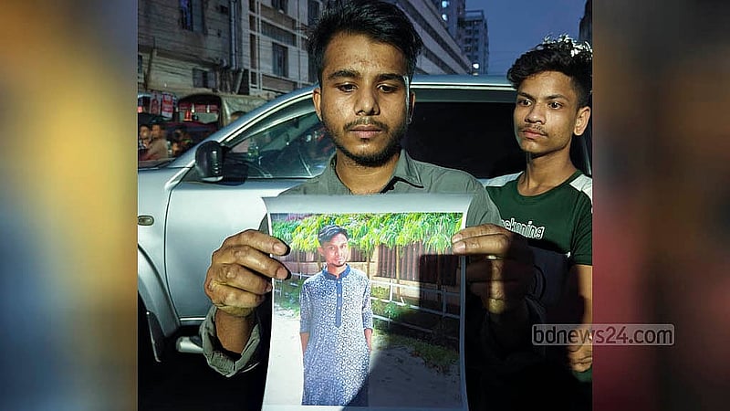 রাজধানীর মিরপুরের রূপনগরে মঙ্গলবার পোশাক কারখানা ও রাসায়নিকের গুদামে লাগা আগুনের পর বন্ধু সারোয়ারের ছবি হাতে ঘটনাস্থলে আমানুল্লাহ।