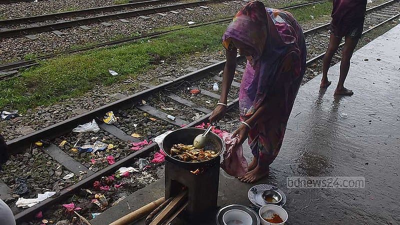 ফাজিলপুর স্টেশনে আশ্রয় নেওয়া বানভাসিরা রান্না করছেন স্টেশনের টিউবওয়েলের পানিতে।