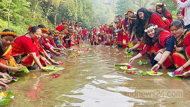 হারি বৈসুতে নদীতে ফুল ভাসাচ্ছেন ত্রিপুরা নারীরা। ফাইল ছবি