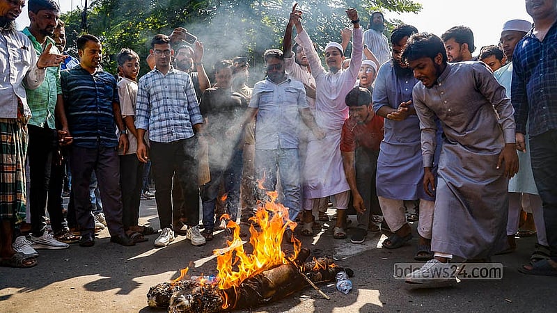 মানবতাবিরোধী অপরাধের মামলার রায় ঘোষণার দিন সোমবার ধানমন্ডি ৩২ নম্বরে সড়কের সামনে শেখ হাসিনার কুশপুতুল পোড়ায় একদল ছাত্র-জনতা।