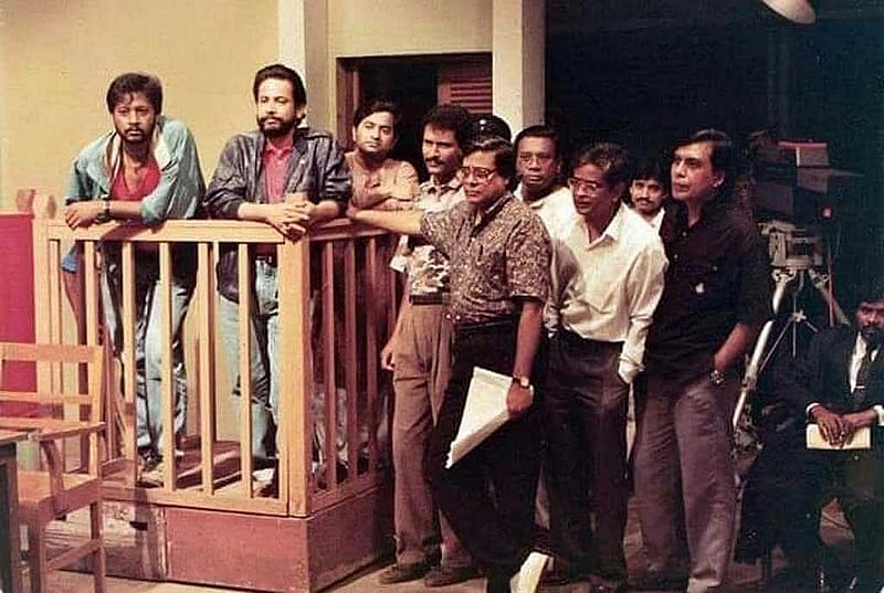 ‘কোথাও কেউ নেই’ নাটকের শুটিং সেটে অভিনেতা আসাদুজ্জামান নূর, আব্দুল কাদের ও কলাকুশলীদের সঙ্গে হ‌ুমায়ূন আহমেদ। 
