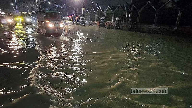 ওয়াসার মোড়ে জলাবদ্ধতা সড়কে চলছে যানবাহন।
