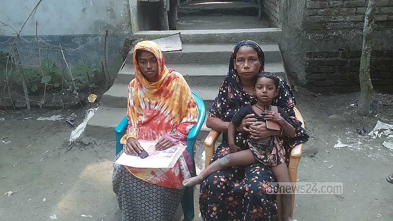 (বাম থেকে) সুজনের স্ত্রী এবং মা; কোলে বসা তিন বছরের মেয়ে নূর।
