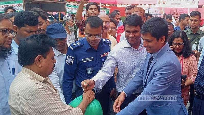 ক্রেতাদের হাতে স্বল্প মূল্যে বাজার তুলে দিচ্ছেন জেলা প্রশাসক। 