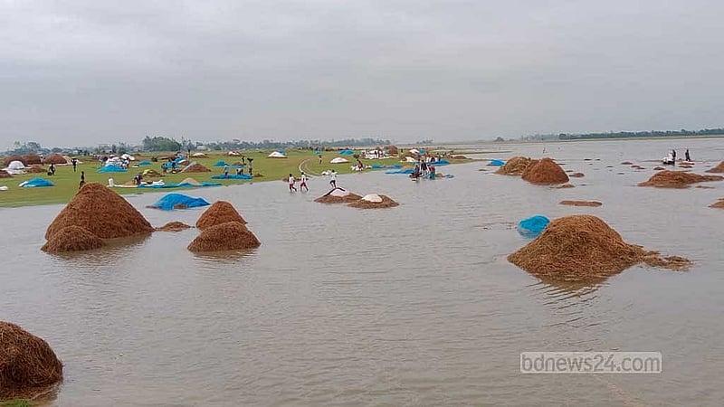 হাওরে খলায় এভাবে পানি চলে আসায় খড় ও ধান শুকাতে পারছেন না কৃষক। 