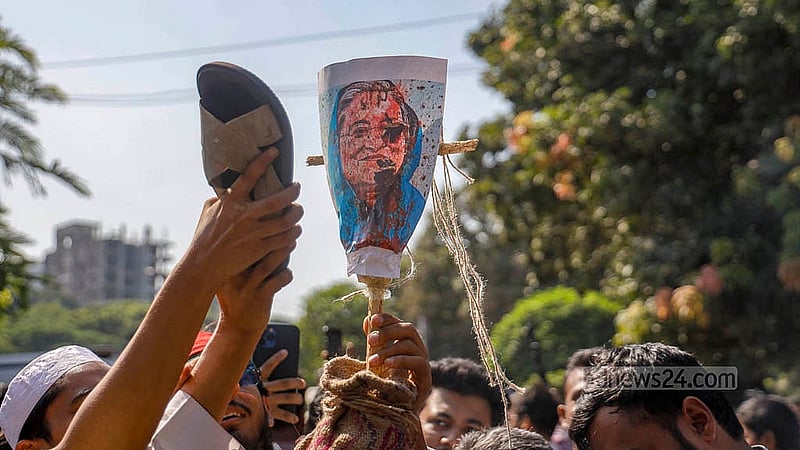 মানবতাবিরোধী অপরাধের মামলার রায় ঘোষণার দিন সোমবার ধানমন্ডি ৩২ নম্বরে সড়কের সামনে শেখ হাসিনার ছবিতে জুতা নিক্ষেপ করে একদল ছাত্র-জনতা।