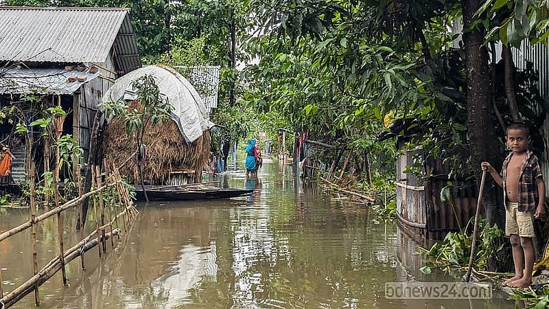 বৃহস্পতিবার দুপুরে সুনামগঞ্জ জেলা শহরের একটি রাস্তায় পানি ভেঙে বাড়ি যাচ্ছেন দুই নারী।