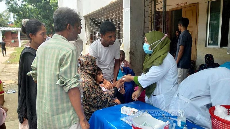 ফেনী জেনারেল হাসপাতাল চত্বরের বাইরে ডায়রিয়া রোগীদের চিকিৎসা ও ভর্তি নিচ্ছেন একজন নার্স।