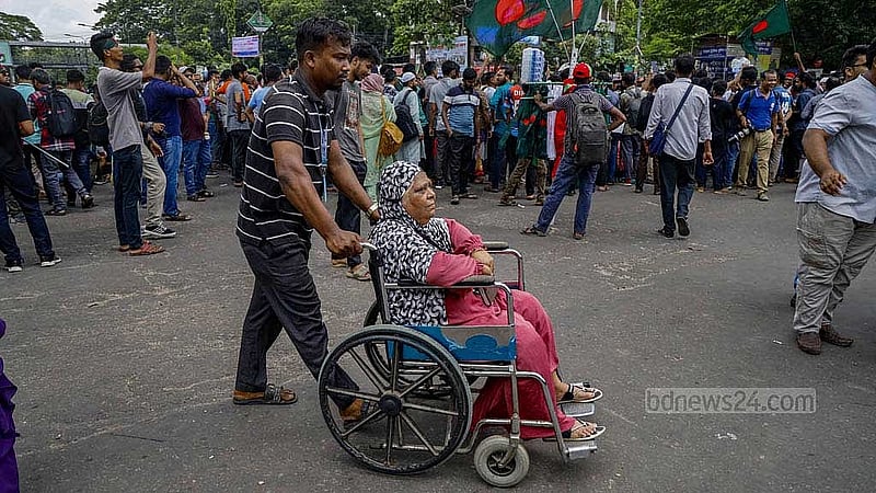 শাহবাগ মোড় অবরোধ করায় বারডেম হাসপাতাল থেকে এক রোগীকে নিয়ে তার স্বজনকে এভাবেই রাস্তা পার হতে দেখা যায়। 