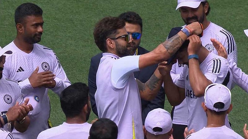 নিতিশের টেস্ট অভিষেকে তার মাথায় ক্যাপ তুলে দিচ্ছেন ভিরাট কোহলি। ছবি: ভিডিও থেকে স্ক্রিনশট
