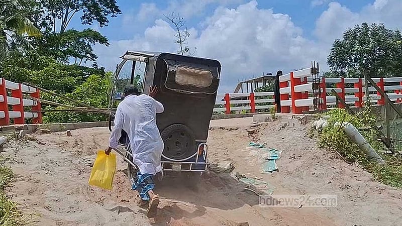 সংযোগ সড়ক না থাকায় ঝুঁকি নিয়ে ধাক্কা দিয়ে ব্রিজে অটোরিকশা ওঠাচ্ছেন যাত্রীরা। 