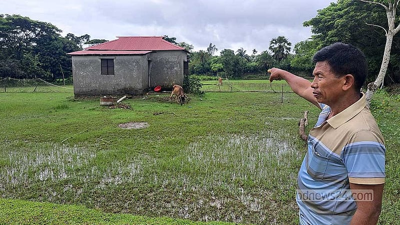 লাউপাড়া পল্লির মাতবর চিং তেন মং শ্মশানের মাঝখানে গড়ে ওঠা ঘর দেখাচ্ছেন।