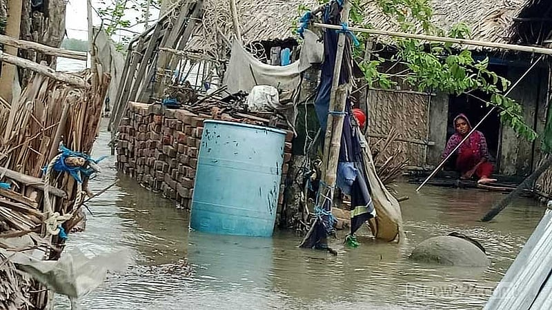 খুলনার দাকোপ উপজেলার সুতারখালি এলাকার ঝুলন্ত পাড়ায় ডুবে যাওয়া বাড়ির দরজায় বসে আছেন অসহায় এক নারী।