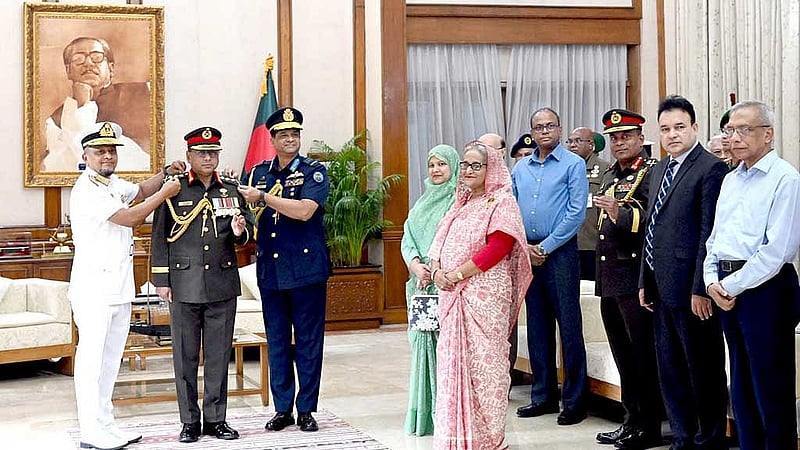 প্রধানমন্ত্রী শেখ হাসিনার উপস্থিতিতে রোববার গণভবনে নতুন সেনাপ্রধান জেনারেল ওয়াকার-উজ-জামানকে র‌্যাংক ব্যাজ পরিয়ে দেন নৌবাহিনী প্রধান অ্যাডমিরাল মোহাম্মদ নাজমুল হাসান এবং বিমানবাহিনী প্রধান এয়ার মার্শাল হাসান মাহমুদ খাঁন। ছবি: আইএসপিআর 