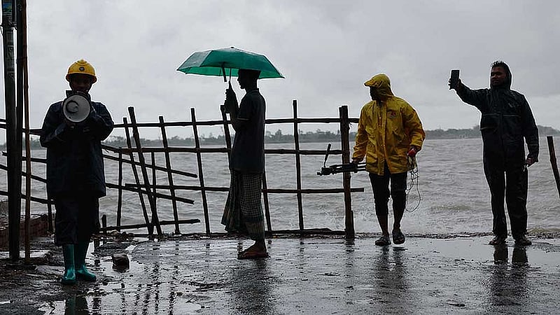 বাংলাদেশের সাতক্ষীরা জেলায় ঘূর্ণিঝড়ের মধ্যে লোকজনকে সতর্ক করছেন কয়েকজন স্বেচ্ছাসেবক। ছবি: রয়টার্স