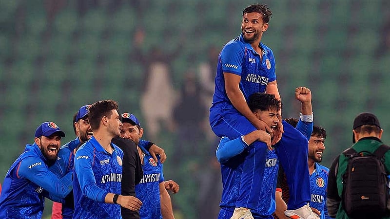 জয়ের পর উল্লসিত আফগান ক্রিকেটাররা, এক সতীর্থের কাঁধে ওমারজাই। ছবি: রয়টার্স