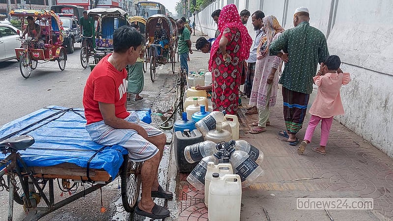 রাজধানীর ইত্তেফাক মোড়ে বঙ্গভবন কলোনির ৫ নম্বর গেইটের সামনে ফুটপাতে থাকা কল থেকে খাবার পানি সংগ্রহে করছেন অনেকেই