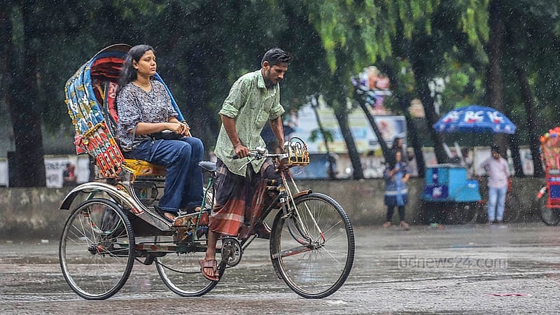 রিকশার ছাউনি খুলে বৃষ্টি উপভোগ। ঢাকা বিশ্ববিদ্যালয় এলাকা থেকে তোলা।  ছবি: আব্দুল্লাহ আল মমীন