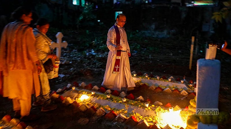 ‘অল সোলস ডেতে’ মৃতদের আত্মার শান্তি কামনায় ঢাকার ওয়ারীতে খ্রিষ্টান সমাধিতে প্রার্থনা শেষে গোলাপ জল ছিটাচ্ছেন ফাদার। ছবি: মাহমুদ জামান অভি