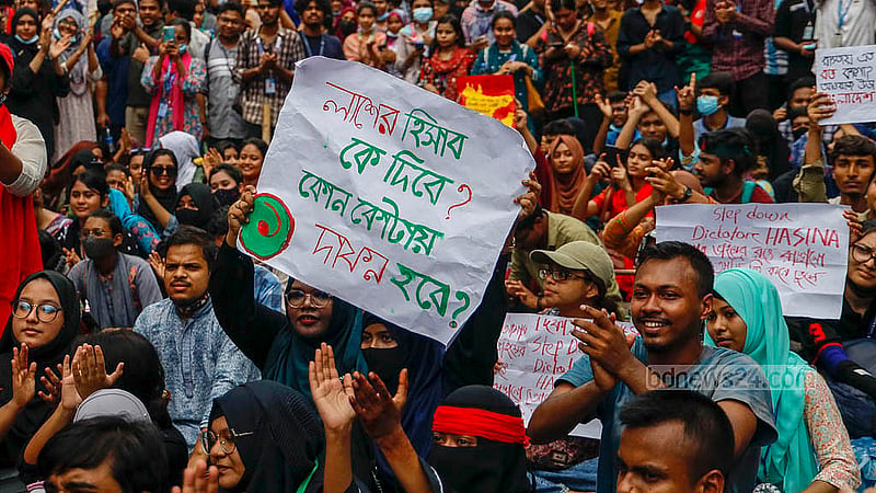 বিভিন্ন দাবির প্ল্যাকার্ড হাতে শনিবার ঢাকার আফতাবনগরের ইস্ট ওয়েস্ট বিশ্ববিদ্যালয়ের সামনে শিক্ষার্থীরা। ছবি: মাহমুদ জামান অভি