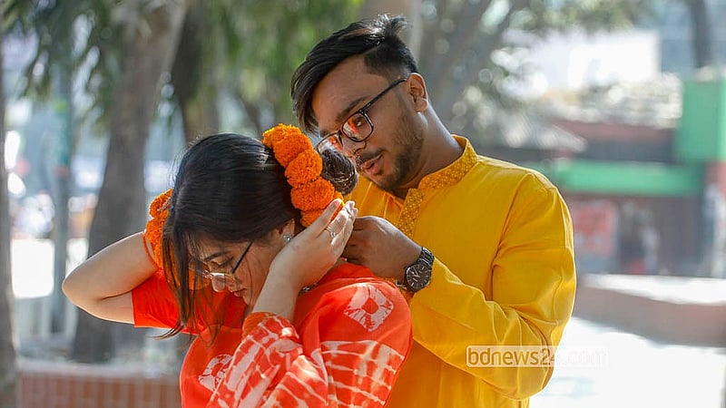 ঢাকা বিশ্ববিদ্যালয়ের টিএসসি এলাকায় তরুণীর মাথায় ফুল পরিয়ে দিচ্ছে একজন